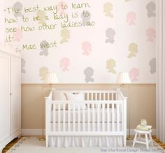 a baby's room with a white crib and pink wallpaper on the walls