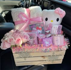 a hello kitty hamper with pink roses and other items in the back seat of a car