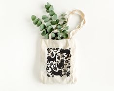 a tote bag with plants in it on a white surface