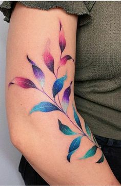 a woman's arm with colorful leaves on it