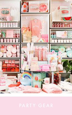 a room filled with lots of pink and white items next to shelves full of food