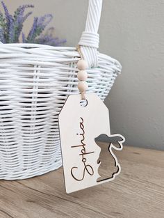 a white basket with a wooden name tag on it