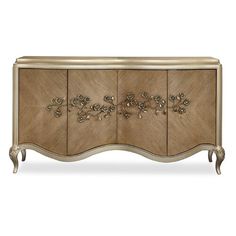 an ornately decorated sideboard with gold trimmings and flowers on the doors