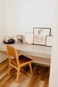 a wooden chair sitting in front of a white desk with pictures on top of it