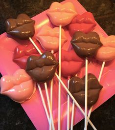 chocolate lips are on top of marshmallows on a pink plate