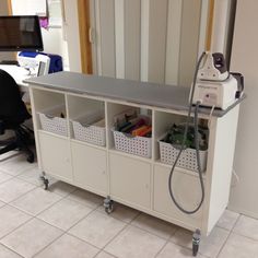 a room with a computer desk and several bins on it