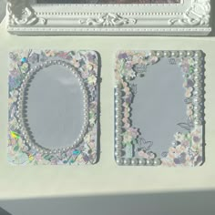 two decorative mirrors sitting on top of a table