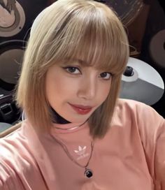 a woman with blonde hair and bangs posing for a photo in front of a record player