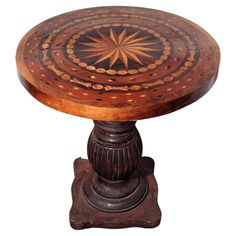 a wooden table with an intricate design on it's top and base, against a white background