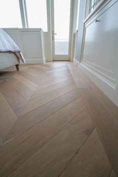 an empty room with wooden floors and white walls