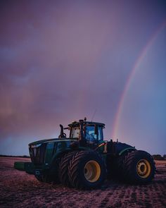 a tractor with a rainbow in the background