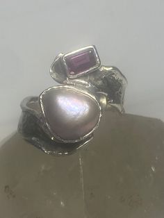 "Pearl ring garnet band Lulu boho sterling silver women Size 8 Weight 8.1g Length 3/4\" Width 1/2\" Thinnest part 1/4\" Free Shipping & Free Postal Insurance Delivered in a Gift Box If you do not want the ring polished and want to leave the natural patina please let me know at the time of purchase as I do polish rings before I ship rings out. Thanks Free First Class shipping and postal insurance is included. If you want to upgrade to priority kindly pay an additional fee to do so. This is recomm Elegant Stackable Rings With Natural Stones For Anniversary, Silver Jewelry With Ethical Gemstones In Open Band, Silver Sterling Stackable Rings With Natural Stones, Elegant Silver Stackable Rings With Natural Stones, Silver Stackable Open Pearl Ring, Silver Birthstone Ring With Natural Stones For Anniversary, Artisan Silver Gemstone Rings, Unique Silver Moonstone Ring In Sterling Silver, Silver Gemstone Stackable Rings Fine Jewelry