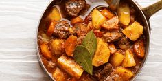 meat and potatoes stew in a pan with a green leaf on the side, ready to be eaten