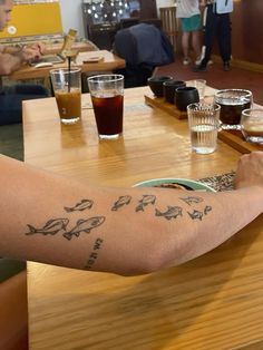 a person sitting at a table with food and drinks in front of them on their arm