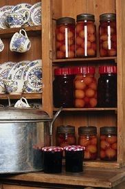 an old wooden cabinet filled with lots of jars and containers full of food on top of it