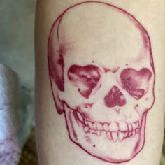 a skull tattoo on the leg of a person's leg, with red ink