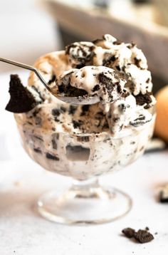 an ice cream sundae with cookies and oreo chips in it on a table