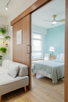 a white couch sitting next to a bed in a living room under a light fixture