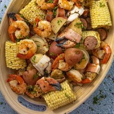 a bowl filled with shrimp, corn and potatoes