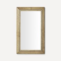 a wooden framed mirror hanging on the wall with a light brown frame and wood trim