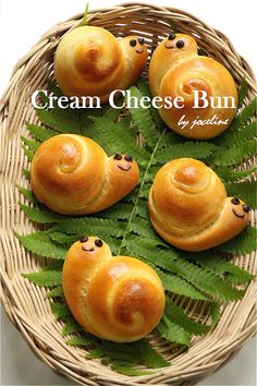 four croissant buns sitting on top of a green leafy plant in a wicker basket