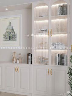 a living room with white bookcases and gold handles on the door knobs