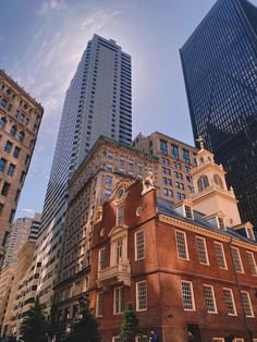 an old brick building in the middle of some tall buildings