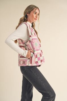 a woman is standing with her back to the camera wearing a pink quilted bag