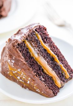 a piece of chocolate cake with frosting and caramel drizzle on top