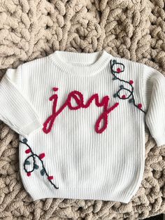 a white sweater with the word joy written on it