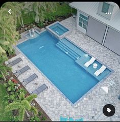 an aerial view of a swimming pool with lounge chairs