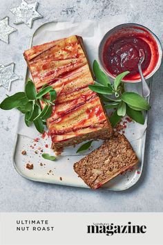 two slices of cake on a plate next to some sauces and green sprigs