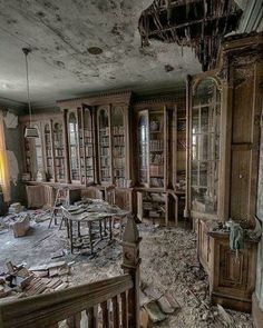 an old room with bookshelves and tables in the middle of it, surrounded by debris