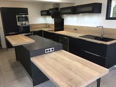 a kitchen with black cabinets and wooden counter tops