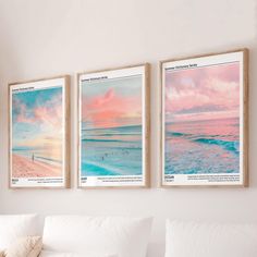 three framed pictures hang on the wall above a couch in a living room with white furniture