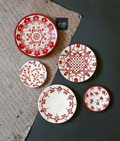 three red and white plates sitting next to each other on top of a piece of paper