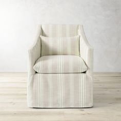 a white chair sitting on top of a hard wood floor next to a wall in an empty room