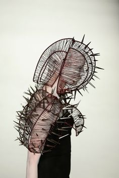 a person holding an umbrella over their head with spikes on it's face and hands