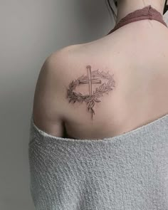 a woman with a cross tattoo on her shoulder