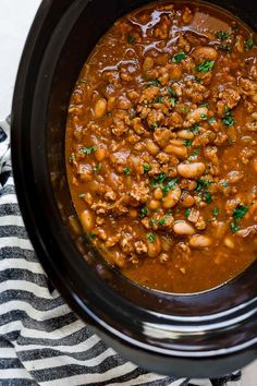 a crock pot filled with beans and meat