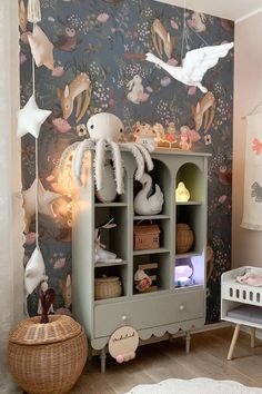 a child's room with an octopus theme on the wall and toys in the cupboard