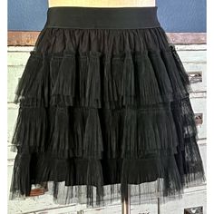 New With Tags Size Medium This Flirty Black Skirt By Elan Has Layers Of Tulle. The Mini Skirt Has A Comfortable Elastic Waistband. It Is A Pull-On Style. The Fabric Is 100% Polyester. Measurements Laying Flat: Length 17 1/4” Waist Elastic 13 3/4” Hips 22” Black Tulle Bottoms For Night Out, Black Tiered Tulle Skirt, Black Tulle Mini Skirt For Summer, Black Tulle Mini Skirt For Spring, Black Mini Tulle Skirt, Black Tiered Skirt For Night Out, Black Pleated Tiered Skirt, Tulle Mini Skirt For Night Out, Tulle Mini Skirt