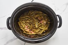 cooked green beans in the crock pot on top of a marble countertop, ready to be eaten