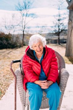 an elderly woman sitting in a chair outside