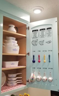 the kitchen cabinet is filled with dishes and utensils for cooking or baking,