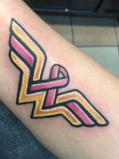 a woman's arm with a pink and yellow ribbon tattoo on her left arm