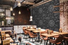 an empty restaurant with wooden tables and chairs, brick walls and black and white patterned wallpaper