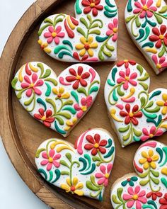 decorated heart shaped cookies on a wooden platter