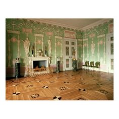 an ornate room with green walls and wooden floors