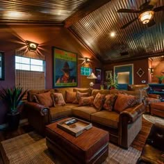 a living room filled with lots of furniture and paintings on the wall above it's windows